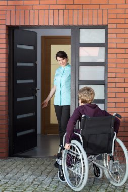 Huzurevi için tekerlekli sandalye üzerinde Caregiver davetkar kadın