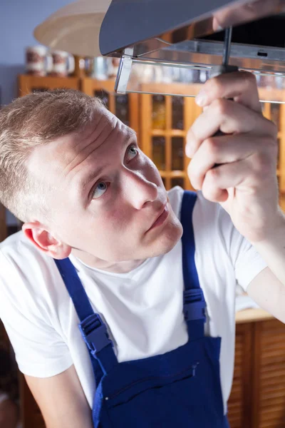 Handyman fixing extractor with screwdriver — Stock Photo, Image