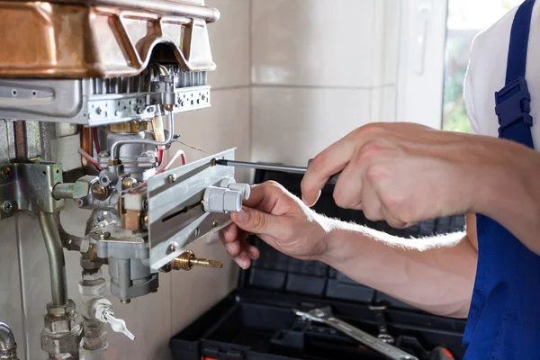 Handyman ajustando aquecedor de água a gás — Fotografia de Stock