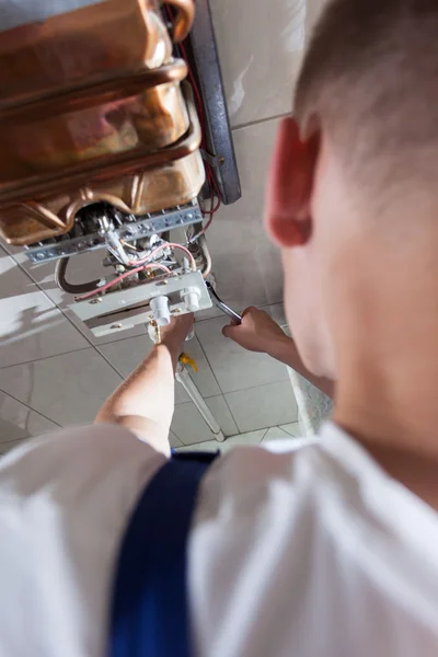 Plumber fixing gas water heater — Stock Photo, Image