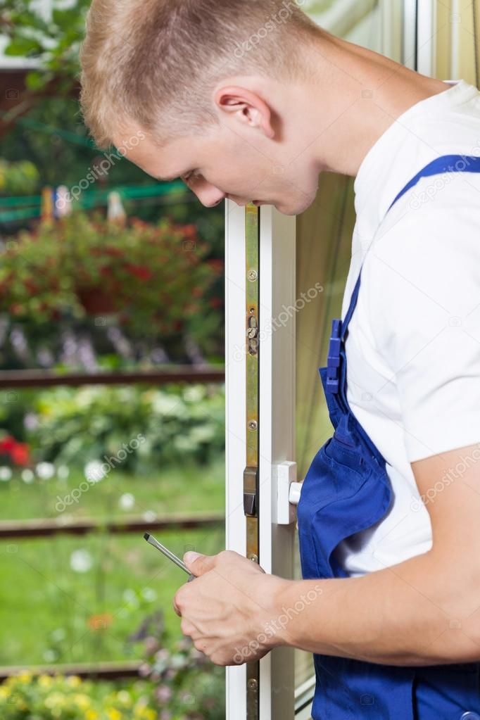 Young man repairing a window