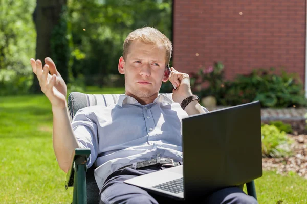 Zakenman die werken in een tuin — Stockfoto