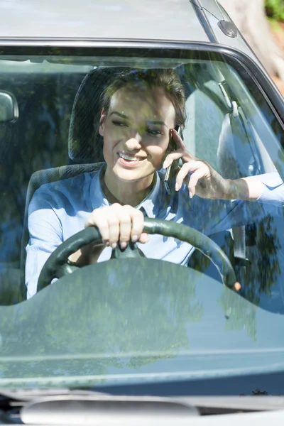 Woman on phone while driving — Stockfoto