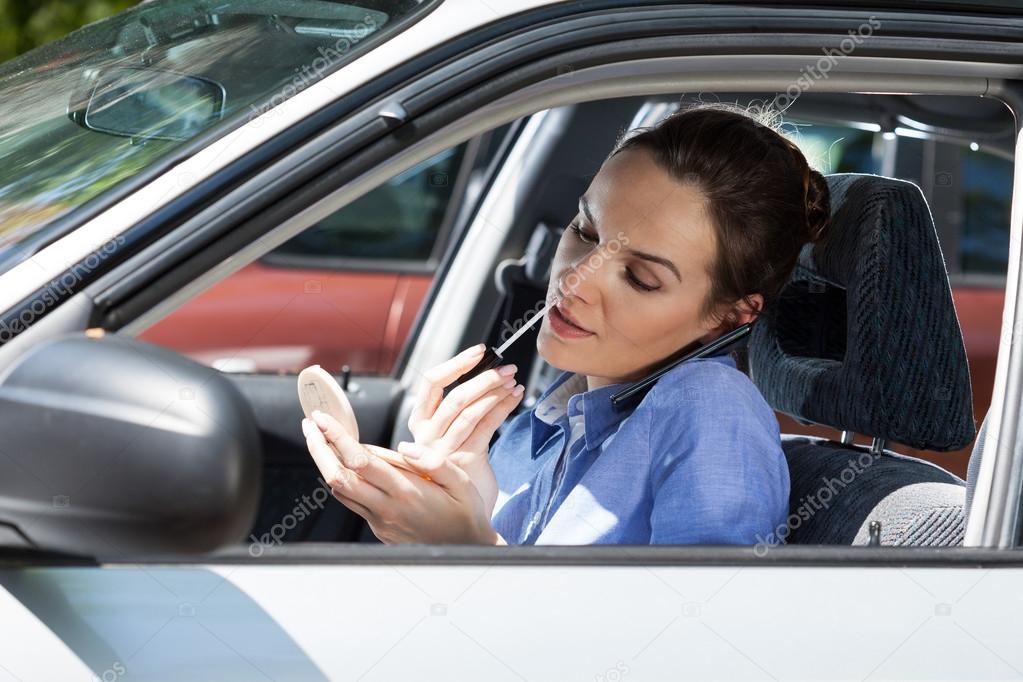 Woman doing makeup in car
