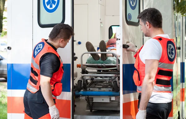 Mujer acostada en camilla en ambulancia — Foto de Stock