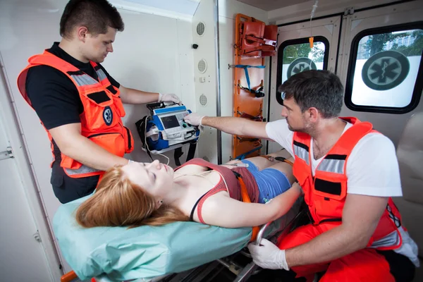 Paramédicos aplicando primeiros socorros em ambulância — Fotografia de Stock