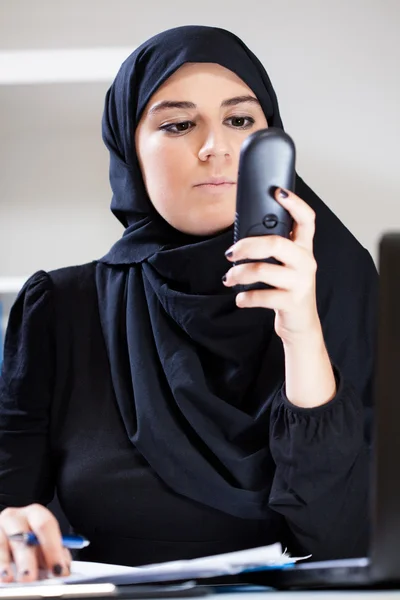 Muslimska kontor arbetaren anläggning telefonerna — Stockfoto