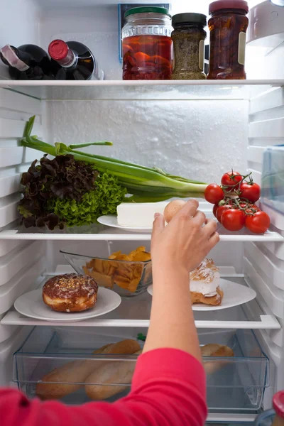 Γυναίκα επιλογή τροφίμων από το ψυγείο — Φωτογραφία Αρχείου