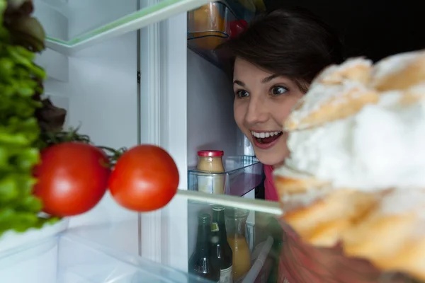 Menina feliz olhando para a geladeira — Fotografia de Stock