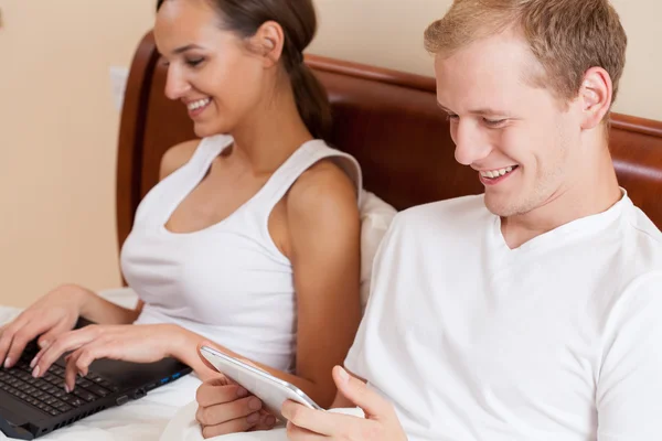 Pareja usando internet en la cama — Foto de Stock