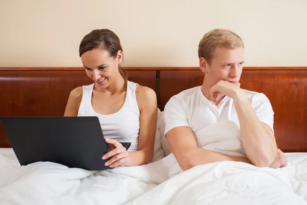 Bored husband and wife with laptop — Stock Photo, Image