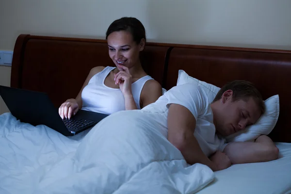 Vrouw met laptop in plaats van slapen — Stockfoto