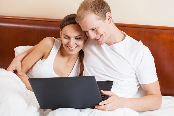 Couple with laptop in bed — Stock Photo, Image