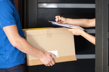 Woman signing parcel delivery papers