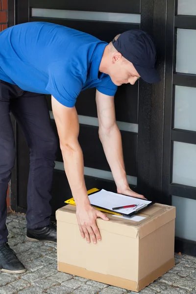 Entrega homem colocando para baixo parcela — Fotografia de Stock