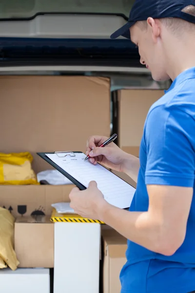 Delivery guy filling in documents — Stock Photo, Image