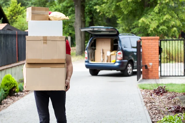 Uomo di consegna che trasporta pacchetto stack — Foto Stock