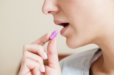 Close-up of woman taking pill clipart