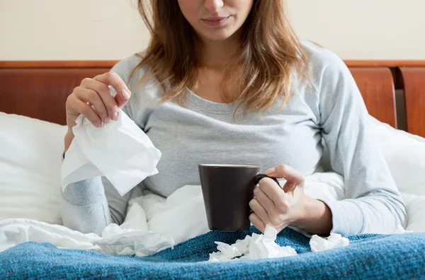 Mulher na cama tendo um resfriado — Fotografia de Stock