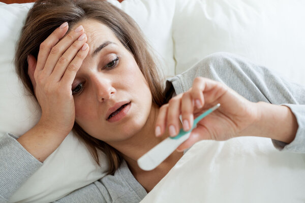 Woman with fever in bed