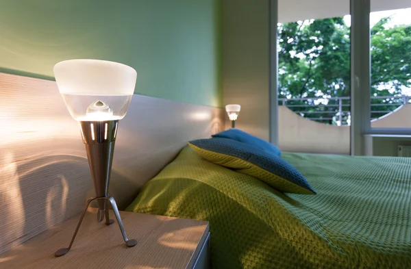 Groene slaapkamer met moderne lampen — Stockfoto