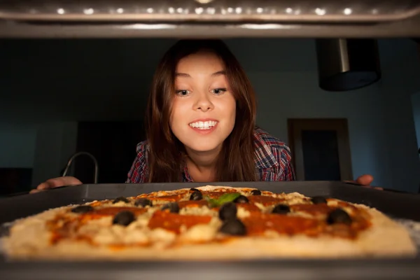 Ragazza felice mettere la pizza in forno — Foto Stock