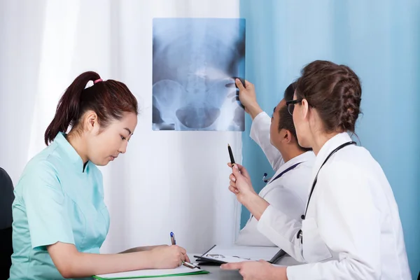 Doctors analyzing x-ray — Stock Photo, Image