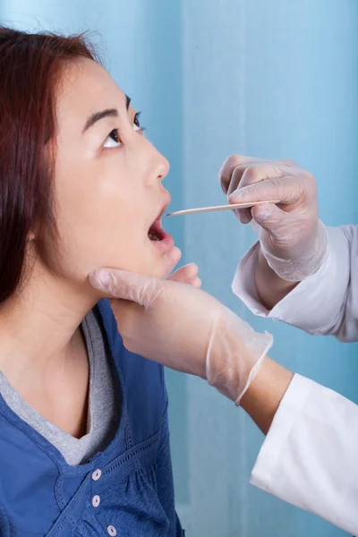 Mongolian woman during throat examination — Stock Photo, Image