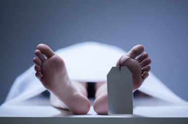 Close-up of human feet in morgue clipart