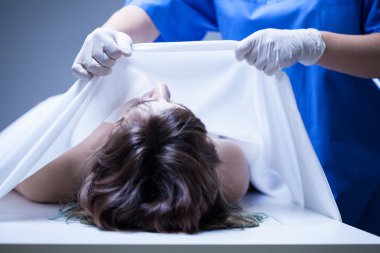 Covering female body in mortuary clipart