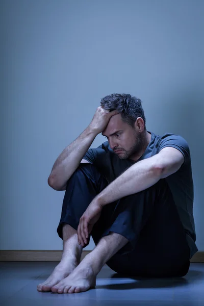 Hombre deprimido sentado en el suelo — Foto de Stock