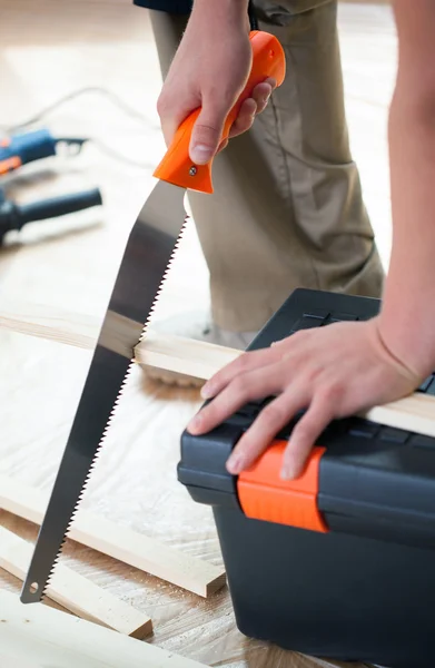 Taglio tavola di legno con sega a mano — Foto Stock