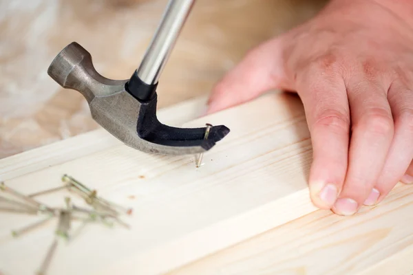 Removing nail from wooden plank using hammer — Stock Photo, Image