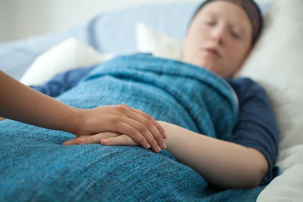 Verpleegster die hand van zieke vrouw — Stockfoto