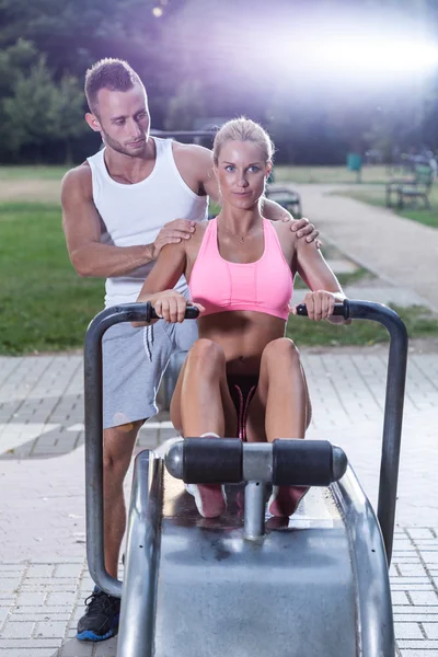 Ajuste mujer usando máquina de remo — Foto de Stock