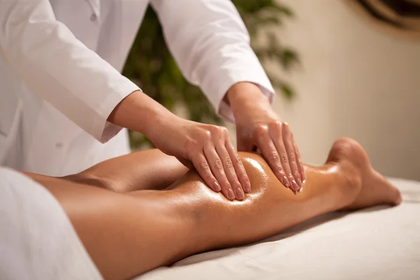 Masseur massaging female calf — Stock Photo, Image