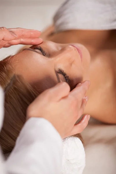 Mulher relaxante durante a massagem facial — Fotografia de Stock