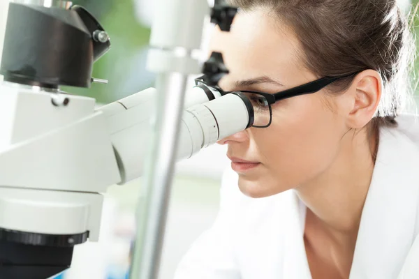 Científico mirando a través del microscopio — Foto de Stock