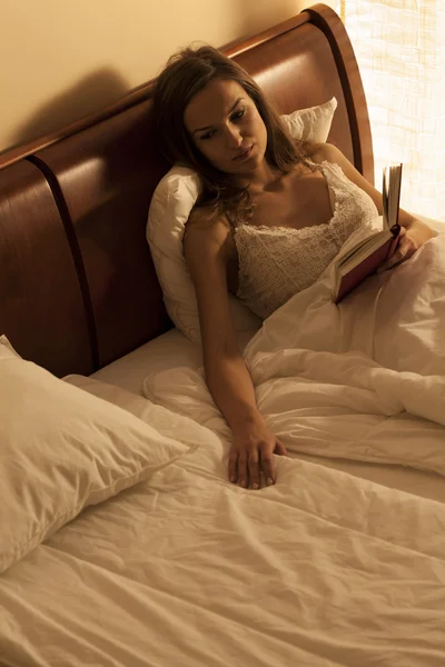 ผู้หญิงนอนบนเตียง ทรมานจากความเหงา — ภาพถ่ายสต็อก