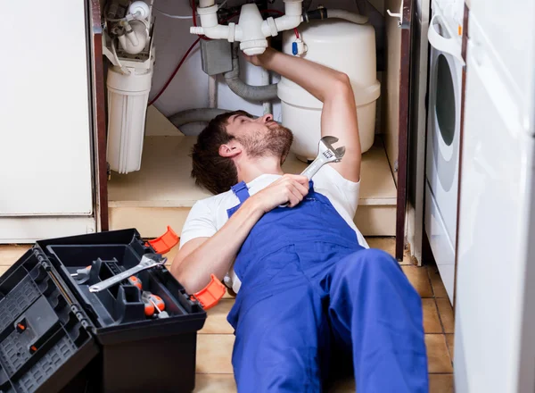 Man repairing pipes in the kitchen Royalty Free Stock Photos