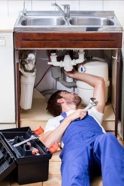 Man repairing kitchen sink Stock Image