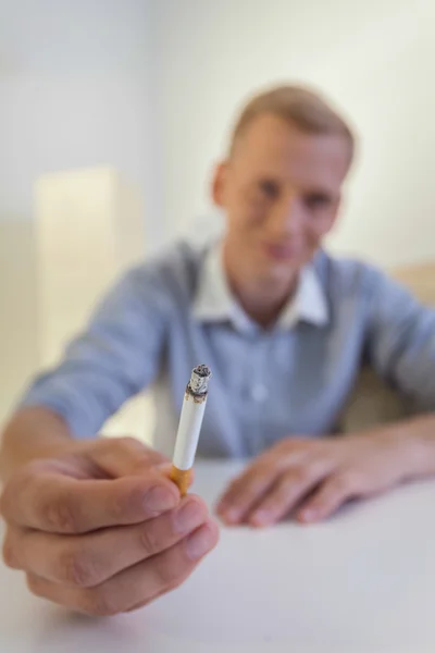 Jovem de camisa segurando um cigarro — Fotografia de Stock