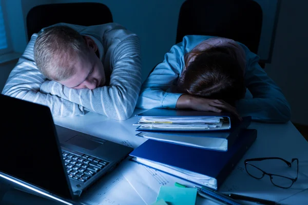 Overwerkte mensen slapen op het werk — Stockfoto