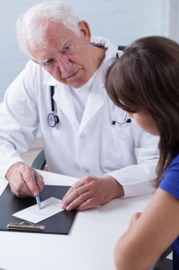Experienced physician giving prescription clipart