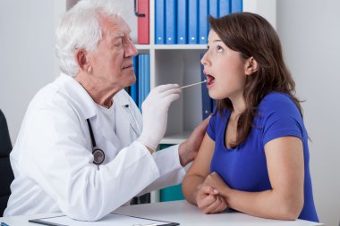 General practitioner examining throat clipart