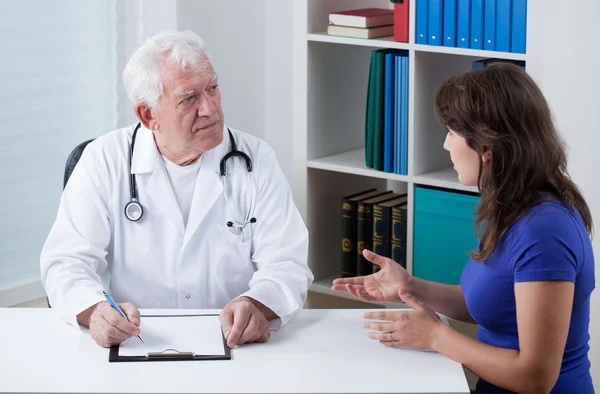 Practiced doctor talking with patient — Stock Photo, Image