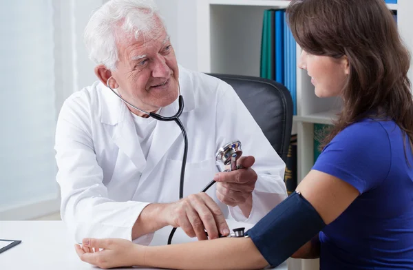 Médico general tomando presión arterial — Foto de Stock