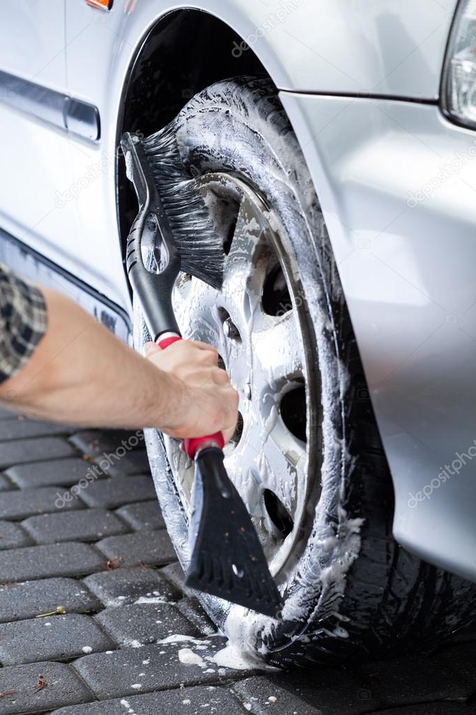 Hand cleaning car wheel