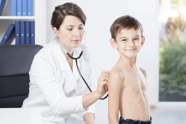 Uśmiechnięty chłopiec zdiagnozowana przez lekarza — Zdjęcie stockowe