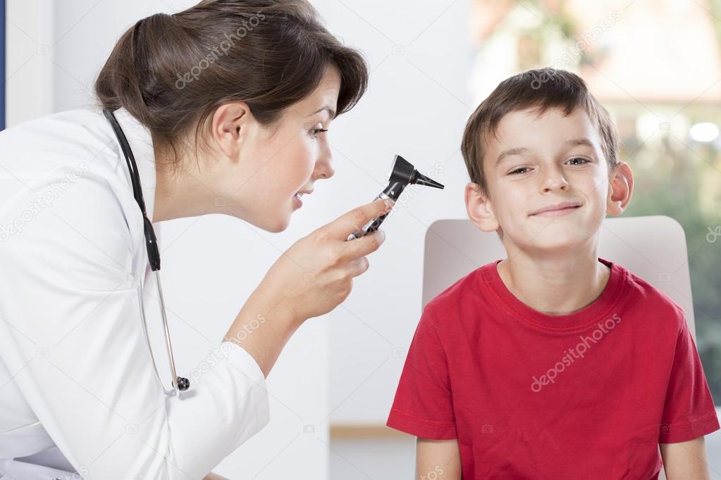 Female pediatrician using otoscope